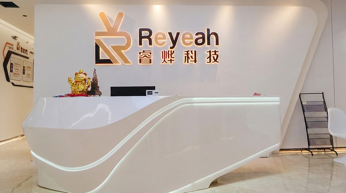 Modern reception area of Reyeah Technology headquarters, featuring the illuminated backlit company logo and a sleek white front desk design