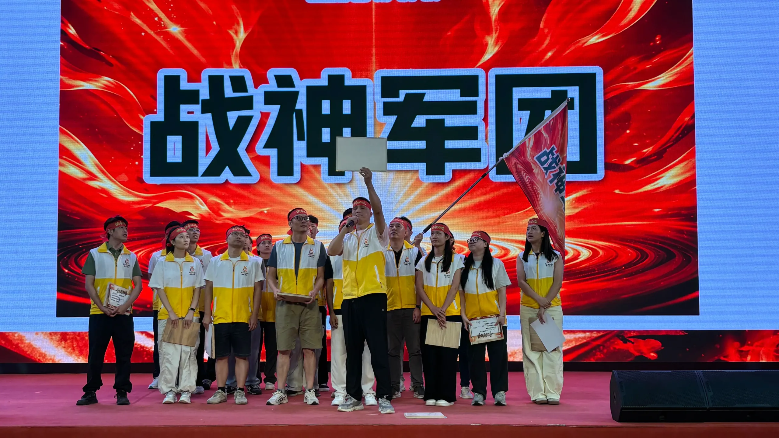 Reyeah sales challenge team making a commitment on stage beneath the campaign display